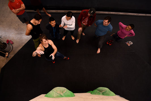 Bouldering Etiquette 101 group of climbers at indoor bouldering gym discuss beta